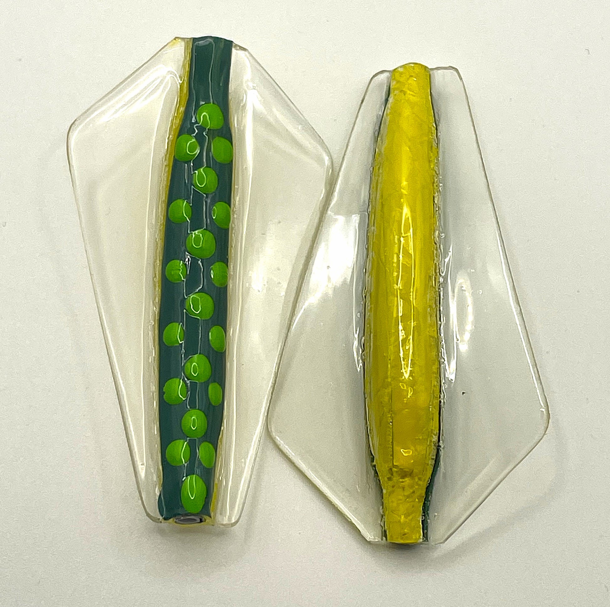 Winged fishing lure that is dark green on top with light green spots and yellow underneath